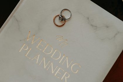 Close-up of a wedding planner book adorned with silver rings, symbolizing preparation and commitment.