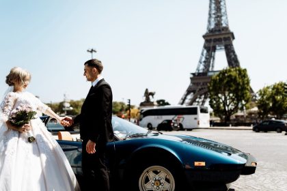 A romantic couple's wedding day captured near the Eiffel Tower in Paris with a luxury car in the foreground.