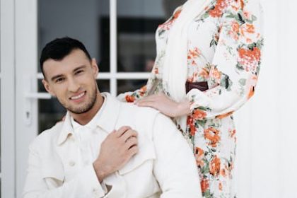 A happy couple poses stylishly, exuding charm and love in elegant floral clothing.