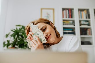 Happy woman with dollar bills, symbolizing financial success and fulfillment.