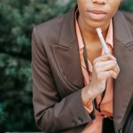 Femme En Blazer Marron Tenant Un Bâton De Cigarette