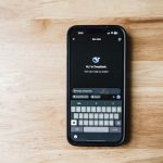 Un smartphone sur une table en bois montrant une interface de chatbot IA appelée DeepSeek.