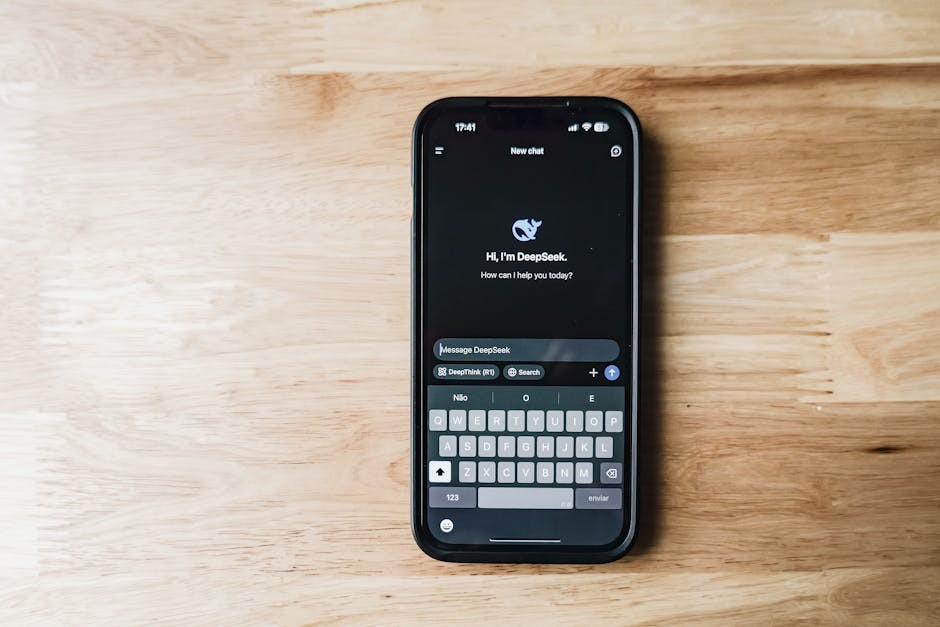 Un smartphone sur une table en bois montrant une interface de chatbot IA appelée DeepSeek.