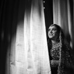 Photo en noir et blanc captivante d'une mariée en tenue traditionnelle aux détails raffinés.