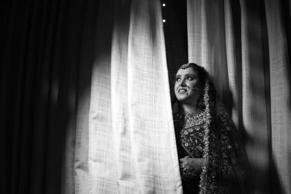 Photo en noir et blanc captivante d'une mariée en tenue traditionnelle aux détails raffinés.