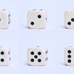 Gros plan détaillé de six dés blancs sur une surface simple, mettant l'accent sur différents nombres.