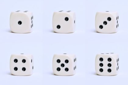 Gros plan détaillé de six dés blancs sur une surface simple, mettant l'accent sur différents nombres.