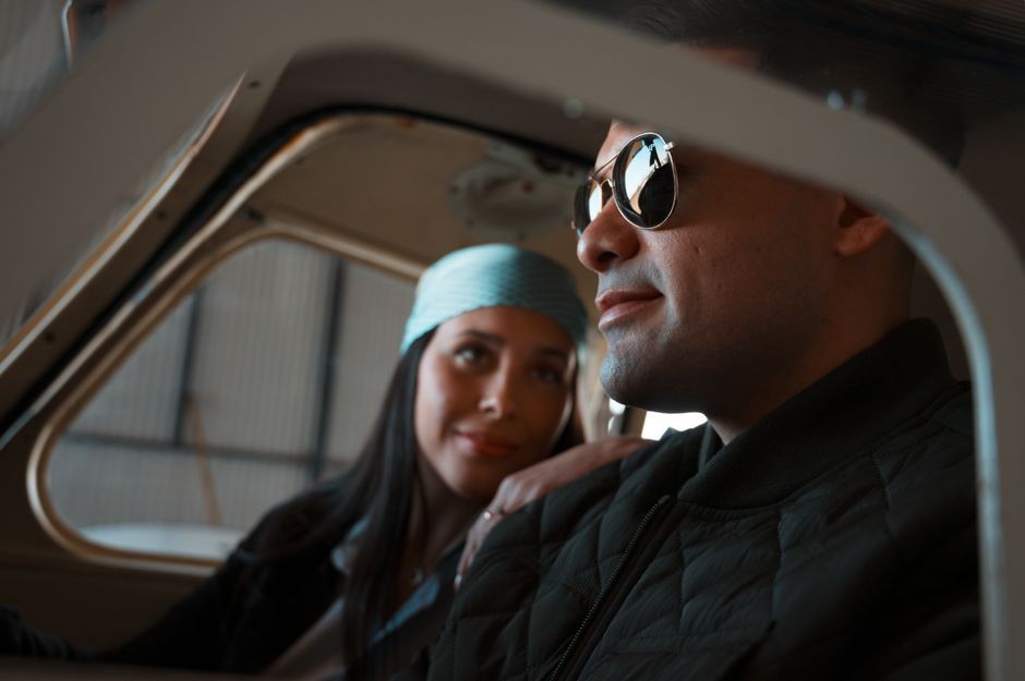 Un couple profite d'un moment de détente dans le cockpit d'un avion, illustrant des thèmes de voyage et d'aventure.