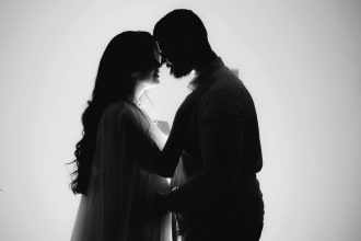 Silhouette d'un couple enlacé, baignée d'une douce lumière, symbolisant l'amour et l'intimité.