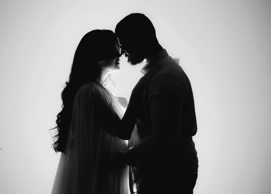 Silhouette d'un couple enlacé, baignée d'une douce lumière, symbolisant l'amour et l'intimité.