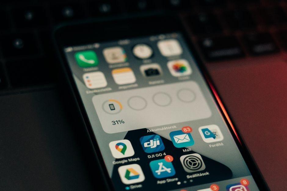 Un smartphone avec diverses applications sur son écran posé sur un clavier, affichant un niveau de batterie de 31 %.